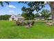 Spacious backyard featuring a firepit with rustic chairs, barn, and a well-maintained lawn at 4499 Highway 308, Aynor, SC 29544