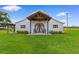 Spacious white barn featuring a covered porch, decorative front doors, and manicured lawn at 4499 Highway 308, Aynor, SC 29544