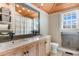 The bright bathroom features double sinks, a large mirror, a toilet, natural light, and rustic accents at 4499 Highway 308, Aynor, SC 29544