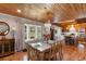 Cozy dining area features wood-paneled ceilings, elegant table setting, large windows and connects seamlessly to the kitchen at 4499 Highway 308, Aynor, SC 29544