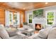 Comfortable living room featuring a fireplace, windows with natural light and wooden walls at 4499 Highway 308, Aynor, SC 29544