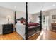 The main bedroom features a regal four-poster bed, natural light, and hardwood flooring for a luxurious retreat at 4499 Highway 308, Aynor, SC 29544