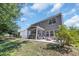 Large backyard featuring a patio, screened-in porch, grassy lawn, and mature trees with string lights at 4501 Farm Lake Dr., Myrtle Beach, SC 29579