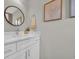 Well-lit bathroom featuring a modern vanity with a round mirror, framed artwork, and a fresh, clean aesthetic at 4501 Farm Lake Dr., Myrtle Beach, SC 29579