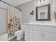 Well-lit bathroom with a patterned shower curtain, ample storage, and modern fixtures at 4501 Farm Lake Dr., Myrtle Beach, SC 29579