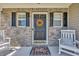 Inviting front door with brick, black shutters, rocking chairs, and fall wreath at 4501 Farm Lake Dr., Myrtle Beach, SC 29579
