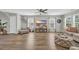 Spacious living room featuring a wood-look floor, a ceiling fan and large windows at 4501 Farm Lake Dr., Myrtle Beach, SC 29579