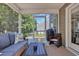 Cozy screened porch with a comfortable sofa, a rattan chair, and a view of the backyard and surrounding foliage at 4501 Farm Lake Dr., Myrtle Beach, SC 29579