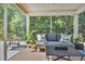 Relaxing screened porch featuring comfortable seating, lush plants, and a serene view of the surrounding greenery at 4501 Farm Lake Dr., Myrtle Beach, SC 29579