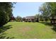 Sprawling backyard features lush lawn, mature trees, stone patio, and outdoor seating for relaxation and recreation at 513 Westham Dr., Murrells Inlet, SC 29576