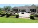 Expansive backyard patio with outdoor kitchen, seating, lush landscaping, and fire pit offers ideal entertaining space at 513 Westham Dr., Murrells Inlet, SC 29576