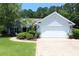 Charming home featuring a well-manicured lawn, lush landscaping, and a two-car garage at 513 Westham Dr., Murrells Inlet, SC 29576