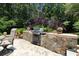 Built-in outdoor kitchen with grill and stone surround, perfect for entertaining on the backyard patio at 513 Westham Dr., Murrells Inlet, SC 29576
