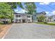 Charming two-story white home featuring gray shutters, a gravel driveway, and a beautifully manicured lawn at 514 6Th Ave. S, Surfside Beach, SC 29575