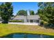 Backyard view of a well-maintained home with lush greenery, a pond, and a privacy fence at 578 Circle Dr., Myrtle Beach, SC 29575
