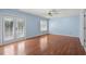 Spacious bedroom with blue walls, ceiling fan, and natural light from a window and french doors at 578 Circle Dr., Myrtle Beach, SC 29575