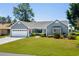 Charming single-story home with a well-manicured lawn, attached garage, and welcoming front porch at 578 Circle Dr., Myrtle Beach, SC 29575