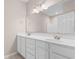 Bathroom with dual sinks, white cabinetry, and large mirror at 5870 Longwood Dr. # 201, Murrells Inlet, SC 29576