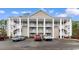 Attractive condo building with multiple stories, external stairs, and ample parking in a serene community setting at 5870 Longwood Dr. # 201, Murrells Inlet, SC 29576