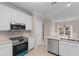 Well-lit kitchen with stainless steel appliances, white cabinets and quartz countertops creating a fresh, clean cooking space at 5870 Longwood Dr. # 201, Murrells Inlet, SC 29576