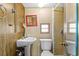 Small bathroom with a pedestal sink, toilet, and a shower stall with tile, offering essential amenities at 6001-1643 S Kings Hwy., Myrtle Beach, SC 29575
