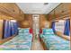 Narrow bedroom featuring twin beds, wood paneling, blue curtains and bedding with access to an ensuite bathroom at 6001-1643 S Kings Hwy., Myrtle Beach, SC 29575