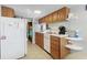 Functional kitchen features wood cabinets, essential appliances, and an adjacent view into the cozy bedroom at 6001-1643 S Kings Hwy., Myrtle Beach, SC 29575