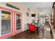 Relaxing covered porch furnished with a dining table, chairs, a fan, and inviting double doors at 6001-1643 S Kings Hwy., Myrtle Beach, SC 29575