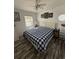 Bright bedroom with white walls, wood-look floors, and a cozy queen-sized bed with a blue and white checkered comforter at 6001-Z67 S Kings Hwy., Myrtle Beach, SC 29575