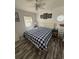 Bright bedroom with white walls, wood-look floors, and a cozy queen-sized bed with a blue and white checkered comforter at 6001-Z67 S Kings Hwy., Myrtle Beach, SC 29575