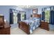 Cozy blue bedroom with wooden furniture, a comfortable bed, and natural light from two windows at 601 Jousting Ct., Conway, SC 29526