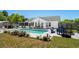Backyard pool area with mature landscaping, seating, patio, and a wooden pergola at 601 Jousting Ct., Conway, SC 29526