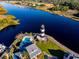 Aerial view showcasing waterfront homes with a pool, lighthouse, and waterway at 6309 N Ocean Blvd. # 14 E, North Myrtle Beach, SC 29582