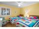 Bright bedroom featuring twin beds with colorful patchwork quilts and sunny yellow walls at 6309 N Ocean Blvd. # 14 E, North Myrtle Beach, SC 29582