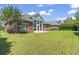 Expansive green backyard showcasing the brick home's sunroom addition and manicured lawn at 806 Compass Point Dr., North Myrtle Beach, SC 29582