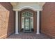 Elegant front entrance with brick facade, decorative door, and white pillars for a grand welcome at 806 Compass Point Dr., North Myrtle Beach, SC 29582