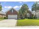 Beautiful brick home with a lush green lawn, mature palm trees, and a spacious driveway at 806 Compass Point Dr., North Myrtle Beach, SC 29582