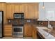 Close-up shot of the kitchen featuring granite countertops, stainless appliances, and wood cabinets at 806 Compass Point Dr., North Myrtle Beach, SC 29582