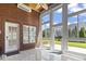 Bright sunroom features brick accent wall, white tile floors, and large windows with a view of the backyard at 806 Compass Point Dr., North Myrtle Beach, SC 29582