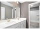 Bathroom featuring a double sink vanity, large mirror, and shower with bath at 8076 Fort Hill Way, Myrtle Beach, SC 29579