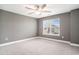 Cozy bedroom featuring a ceiling fan, large window, and neutral colored carpet at 8076 Fort Hill Way, Myrtle Beach, SC 29579