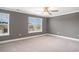 Bedroom with a ceiling fan, carpet, and two windows overlooking a neighborhood at 8076 Fort Hill Way, Myrtle Beach, SC 29579