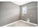 Bright laundry room features gray walls, tile floors, a window, and washer and dryer hookups at 8076 Fort Hill Way, Myrtle Beach, SC 29579