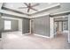 Spacious main bedroom featuring tray ceilings, a ceiling fan, and neutral carpet at 8076 Fort Hill Way, Myrtle Beach, SC 29579