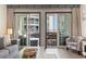 View from living room to balconies with seating for relaxation, showcasing the adjacent building at 920 N Waccamaw Dr. # 2102, Murrells Inlet, SC 29576