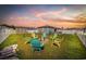 Beautiful backyard at sunset with Adirondack chairs around a fire pit and a storage shed at 924 Akron St., Conway, SC 29526