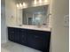 Bathroom vanity with double sinks, dark wood cabinets, and modern fixtures at 9409 Long Meadow Way, Longs, SC 29568