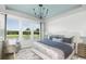 Bright bedroom with large windows, stylish chandelier and contemporary furnishings at 9419 Long Meadow Way, Longs, SC 29568