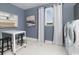 Clean laundry room with washer, dryer, folding table and built-in wall storage at 9419 Long Meadow Way, Longs, SC 29568