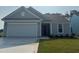 Charming single-story home featuring a two-car garage and well-manicured lawn at 1000 Lady Bird Way, North Myrtle Beach, SC 29582